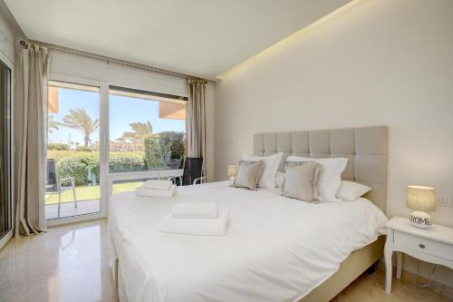 索托格兰德Ribera del Marlin的卧室设有一张白色大床和大窗户