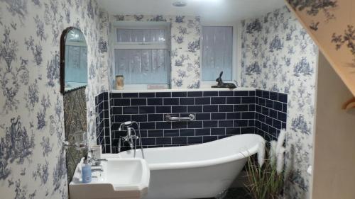 伊斯特布恩樱桃树宾馆的带浴缸、水槽和镜子的浴室