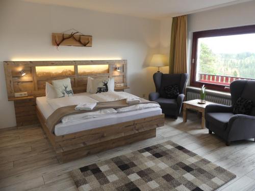霍盖思和谐拉斯特酒店的一间卧室配有一张大床和两把椅子