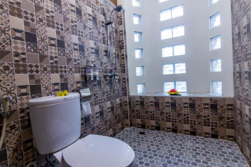 马格朗Maher House Borobudur的一间带卫生间和瓷砖墙的浴室