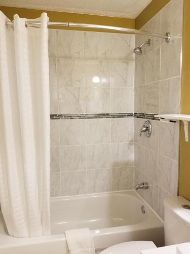 SundreSun Plaza Motel的带浴缸、卫生间和盥洗盆的浴室