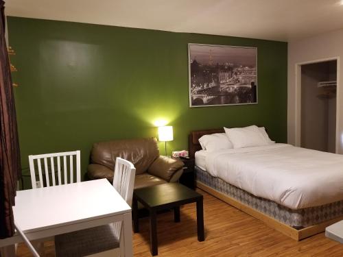 SundreSun Plaza Motel的一间卧室配有一张床、一张沙发和一把椅子