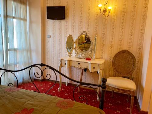 里托楚伦米尔托酒店的一间卧室配有一张床、镜子和椅子