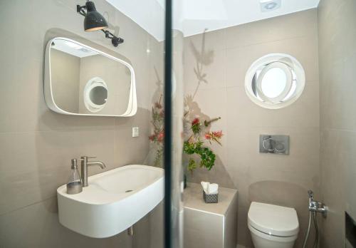 库卡里Eftopia Beachfront Studio的一间带水槽、卫生间和镜子的浴室