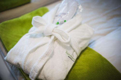 汉诺威艾林瑞德斯提福特公寓酒店的床上的白色毛巾,上面有弓