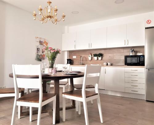 甘迪亚Immaculada Apartament Gandia的厨房配有木桌和白色橱柜。