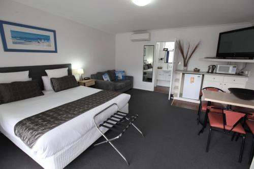 莫宁顿莫宁顿汽车旅馆的一间卧室配有一张床和一张书桌及电视