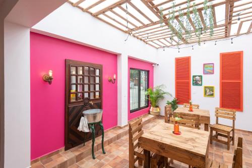 AquismónHotel Boutique Santa Lucía的一间设有粉红色墙壁和木桌的客房