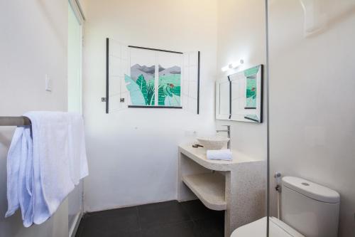 孟威Ohana Retreat Bali的白色的浴室设有卫生间和水槽。