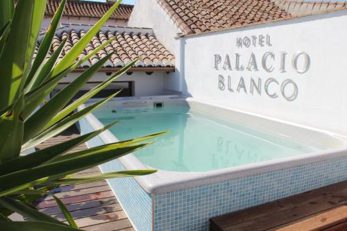 贝莱斯帕拉西奥布兰科酒店的一个带有读取palapablancaambo酒店标志的游泳池