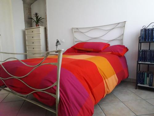 奥西莫La casa di Lalla的一间卧室配有一张带彩色毯子的床