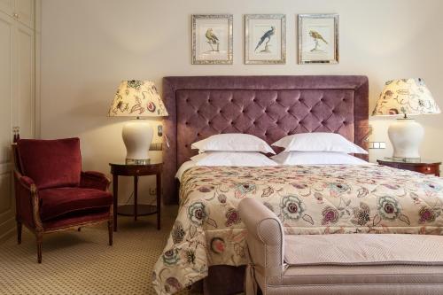 维尔纽斯NARUTIS hotel的一间卧室配有一张大床和一把椅子