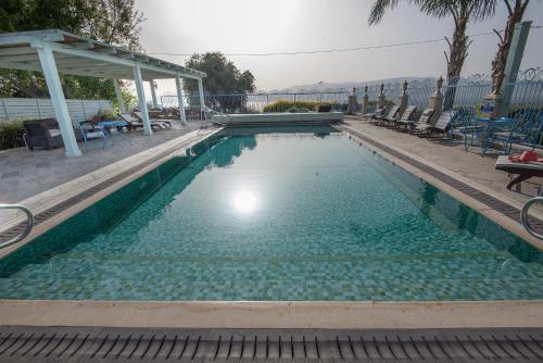 莫沙夫拉莫特加利利海全景酒店的一个带椅子的游泳池和一个凉亭