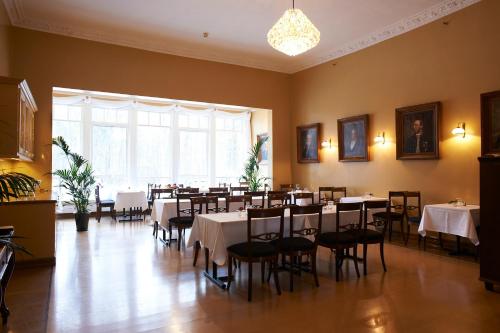 霍尔滕Sjømilitære Samfund的一间带桌椅的用餐室和大窗户