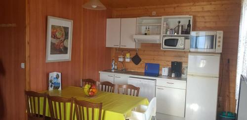 IgnauxISATIS 19的厨房配有桌子和白色冰箱。