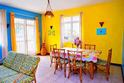特鲁欧克比赫斯Villa les bananniers的用餐室设有黄色的墙壁和桌椅