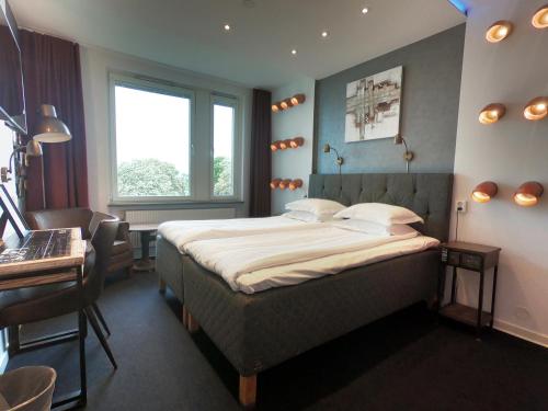 马尔默哈弗舒特莱特酒店的一间卧室配有一张床、一张书桌和一个窗户。