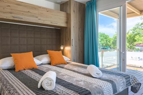 波雷奇Mobile Homes - Lanterna Premium Camping Resort的一间卧室设有两张床和大窗户
