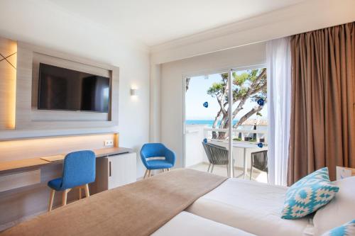 穆罗海滩Grupotel Los Príncipes & Spa的酒店客房设有一张床,享有海景。