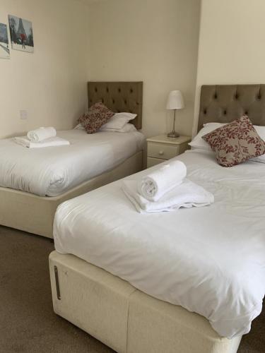 埃文河畔斯特拉特福The Queens Head的配有白色床单的酒店客房内的两张床