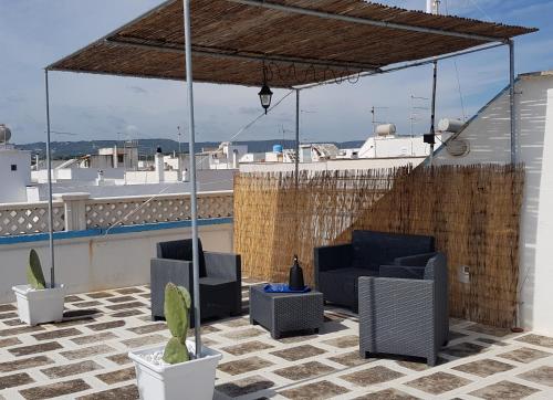 奥斯图尼Aurasia Alla Marina的屋顶露台配有两把椅子和凉亭