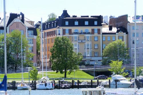 赫尔辛基Kruna by the Sea的一群船在建筑物附近的水中