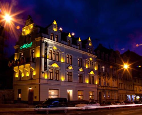 卡罗维发利阿尔弗雷德酒店的一座白色的大建筑,上面有 ⁇ 虹灯标志