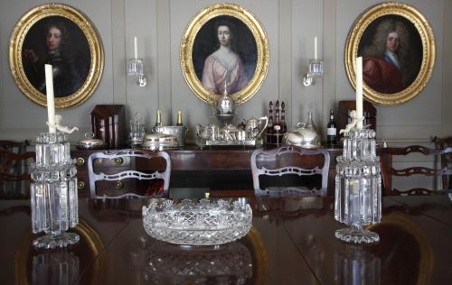 Collon科龙乡村民宿的用餐室配有带玻璃杯和画像的桌子