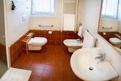 特伦托阿格瑞图尔法德阿迪杰酒店的浴室配有2个盥洗盆、卫生间和盥洗盆。