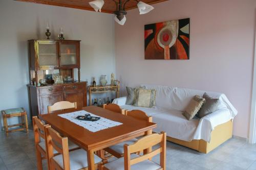 DhavgátaLa Casa di Odyssey的客厅配有桌子和沙发