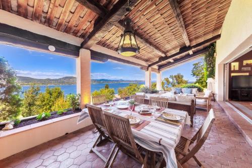 圣特罗佩Villa with Magic view of Bay of Saint Tropez的户外用餐室配有桌子,享有海景