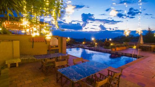 巴里查拉苔拉白瑞察酒店的一个带桌椅的夜间游泳池