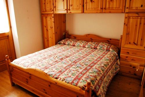 科戈洛Pejo Appartamenti Pegolotti的一间卧室配有一张木架床和橱柜。