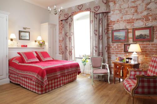 克拉科夫德沃科斯祖泽克酒店的一间卧室设有红色的床和砖墙