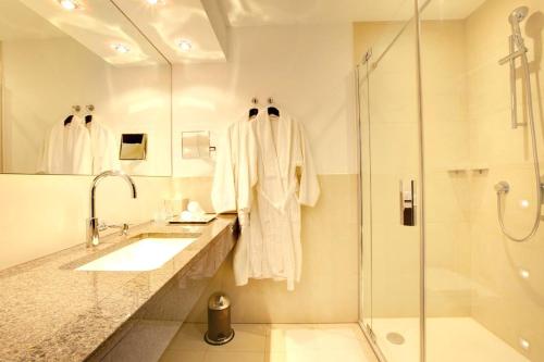 杜塞尔多夫法伍儿酒店的白色的浴室设有水槽和淋浴。
