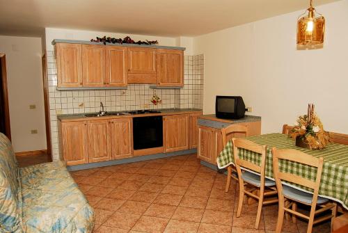 科戈洛Pejo Appartamenti Pegolotti的厨房配有木制橱柜和桌椅
