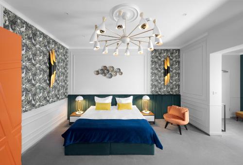 蒂米什瓦拉Hotel Del Corso的一间卧室配有蓝色的床和吊灯。