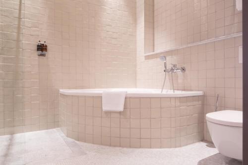 柏林梦碧幽酒店的带浴缸和卫生间的浴室。