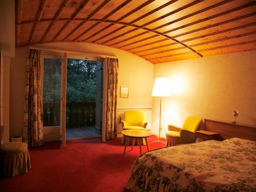 韦尔比耶Arche de Noé B&B的酒店客房带一张床、一张桌子和椅子