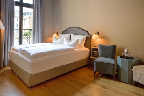 柏林梦碧幽酒店的卧室配有床、椅子和窗户。