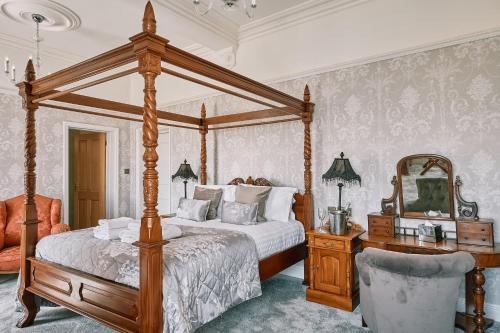莱瑟姆-圣安妮The Queens Hotel的一间卧室配有天蓬床和镜子