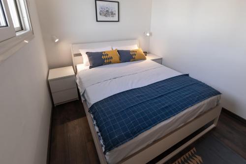 阿斯旺Anakob的小卧室配有蓝色和黄色枕头