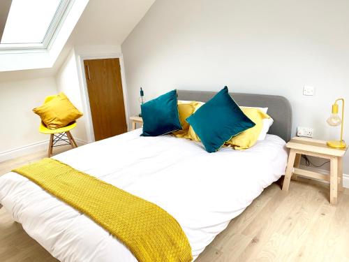 剑桥The Birches的一间卧室配有一张带蓝色和黄色枕头的大床