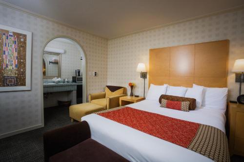 门洛帕克门洛公园旅馆的酒店客房设有一张大床和一张书桌。