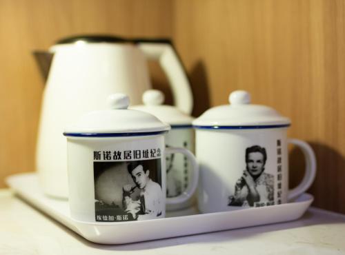 北京Zhong An Hotel Beijing Former Residence of Journalist Edgar Snow的一个带三杯茶壶的书架