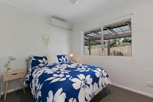 埃尔利海滩Whitsunday Palms by HamoRent的卧室配有蓝色和白色的床和窗户。