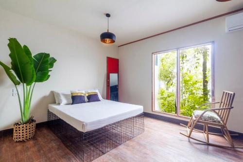 宿务The Flying Fish Hostel Cebu的一间卧室设有一张床、一个窗口和一把椅子