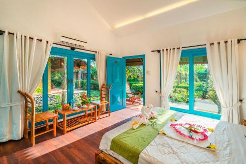 丐县湄公河山林小屋的卧室设有蓝色门和一张床及椅子