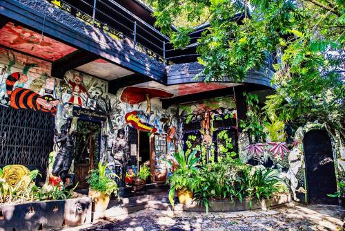 康提赫尔佳思富力安提酒店公寓的一座墙覆盖着涂鸦和植物的建筑
