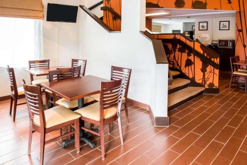 布里奇波特Quality Inn Bridgeport-Clarksburg的一间带桌椅和楼梯的用餐室